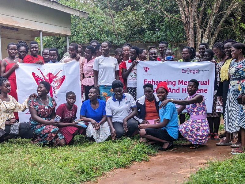 Participants with partner banners after an Esonga MHM training